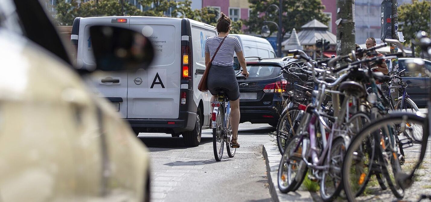 Radfahrerin auf Fahrbahn, bedrängt von Kfz.